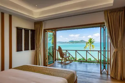 a bedroom with a view of the ocean at Coconut Grove Resort in Ko Yao Yai