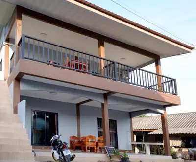 a house with a balcony with a scooter parked in front at WS HOUSE KRABI in Ban Ko Kwang