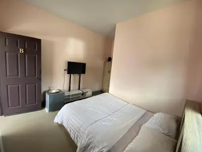 a bedroom with a bed and a door and a television at WS HOUSE KRABI in Ban Ko Kwang