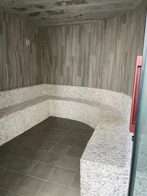 a stone bench in a room with a tile floor at Title V Mountain View Pool View Gym Hammam in Rawai Beach
