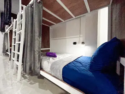 a bedroom with a bunk bed with blue sheets at Magic Hostel in Phi Phi Don