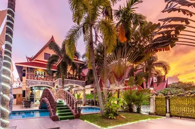 a house with a pool and palm trees at Villa Cologne​ @Nanai Villa in Patong Beach