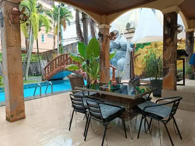 a patio with a table and chairs and a pool at Villa Cologne​ @Nanai Villa in Patong Beach