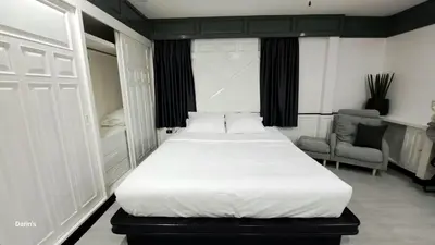 a bedroom with a large white bed and a chair at Villa Cologne​ @Nanai Villa in Patong Beach