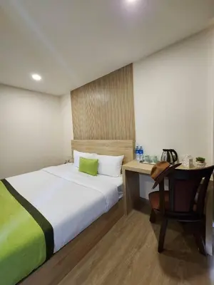 a bedroom with a bed and a desk and a chair at iCheck inn Darisa Patong in Patong Beach