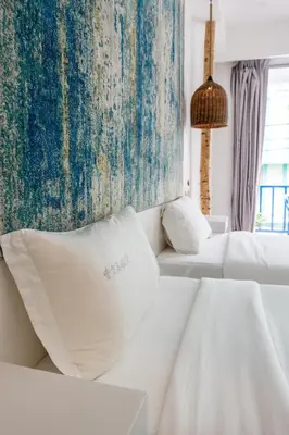 a hotel room with two beds and a rug at Meow Cat Cafe & Hotel in Patong Beach