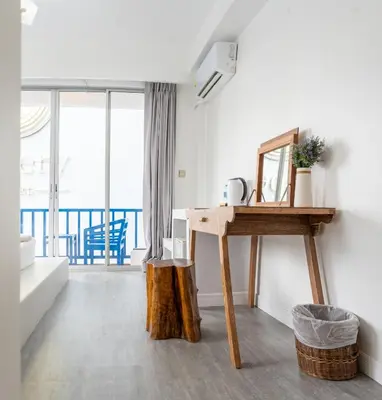 a room with a table and a mirror and a balcony at Meow Cat Cafe & Hotel in Patong Beach