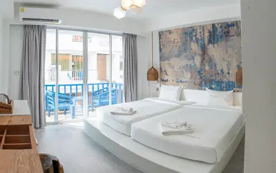 a large white bed in a room with a balcony at Meow Cat Cafe & Hotel in Patong Beach