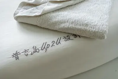 a sign on a towel next to a towel at Meow Cat Cafe & Hotel in Patong Beach