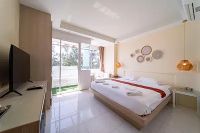 a bedroom with a large bed and a television at Catnip Seaside Hotel&Cafe in Ban Huai Luk (1)
