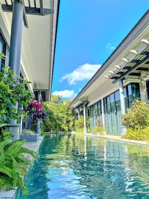 a swimming pool in front of a building at Tajh Pool Villas in Chalong