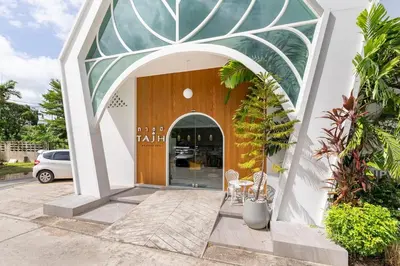 a building with an arched entryway with a table and chairs at Tajh Pool Villas in Chalong