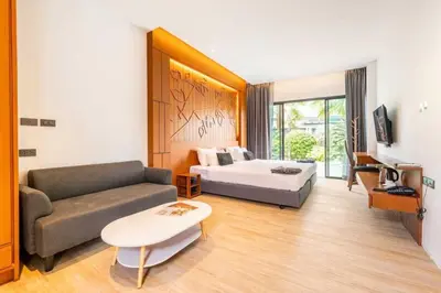 a hotel room with a bed and a couch at Tajh Pool Villas in Chalong