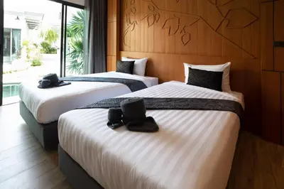 a hotel room with three beds with shoes on them at Tajh Pool Villas in Chalong