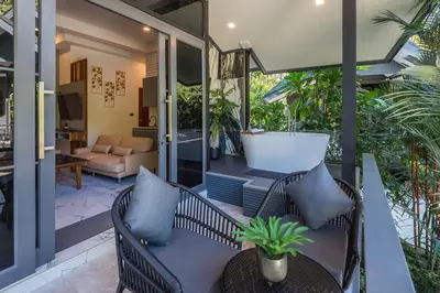 a porch with two chairs and a couch at Loy Chalet in Klong Muang Beach