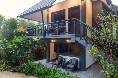a house with two chairs and a balcony at Loy Chalet in Klong Muang Beach