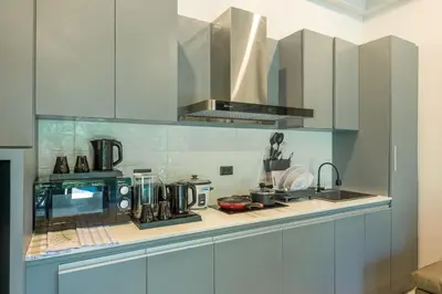a kitchen with white cabinets and a stove top oven at Loy Chalet in Klong Muang Beach