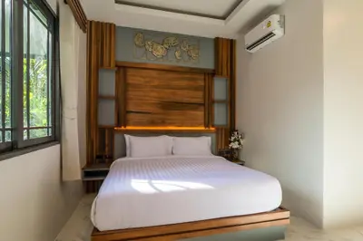 a bedroom with a white bed in a room at Loy Chalet in Klong Muang Beach