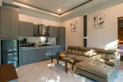 a living room with a couch and a kitchen at Loy Chalet in Klong Muang Beach