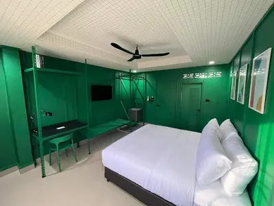 a green bedroom with a bed and a ceiling fan at Sari Boutique hotel in Patong Beach