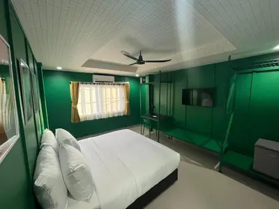 a green room with a bed and a green wall at Sari Boutique hotel in Patong Beach