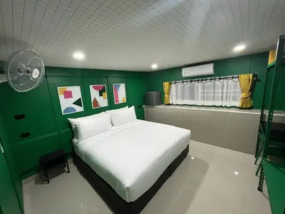 a bedroom with a white bed and a green wall at Sari Boutique hotel in Patong Beach