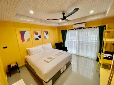 a bedroom with a large bed and a yellow wall at Sari Boutique hotel in Patong Beach