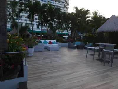 a patio with couches and tables and palm trees at Andaman sea view private in Patong Beach