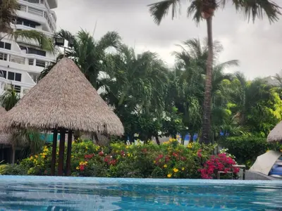 a swimming pool with umbrellas and flowers next to a hotel at Andaman sea view private in Patong Beach