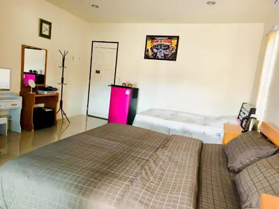 a bedroom with two beds and a desk and a pink refrigerator at Nu Phuket Airport Resident 1 in Nai Yang Beach