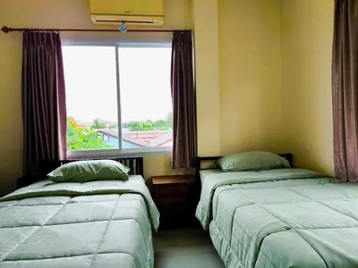 two beds in a room with a window at Nu Phuket Airport Resident 1 in Nai Yang Beach