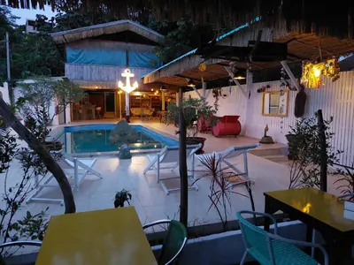 a patio with a pool and tables and chairs at Baan sikhao Yanui in Rawai Beach