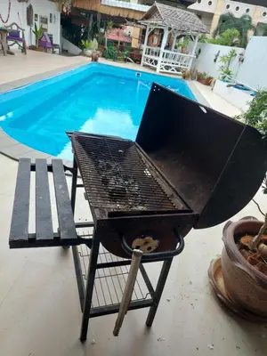 a bbq grill next to a swimming pool at Baan sikhao Yanui in Rawai Beach