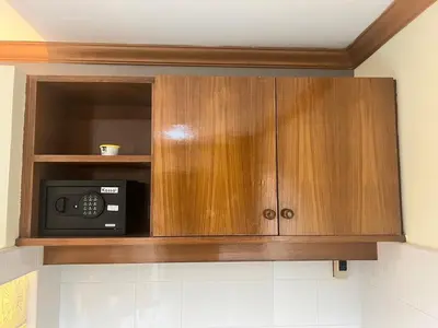 a wooden cabinet with a microwave in a kitchen at Royal Vista Patong in Patong Beach
