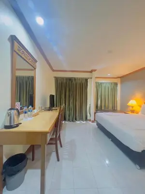 a bedroom with a bed and a desk and a table at Royal Vista Patong in Patong Beach