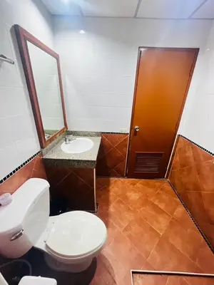 a bathroom with a toilet and a sink and a mirror at Royal Vista Patong in Patong Beach