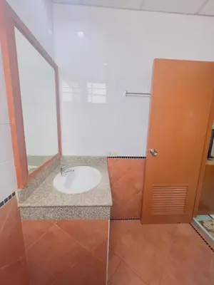 a bathroom with a sink and a glass door at Royal Vista Patong in Patong Beach
