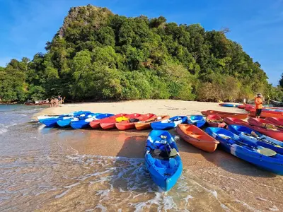 a group of kayaks are lined up on a beach at Hunny Home in Ko Yao Noi