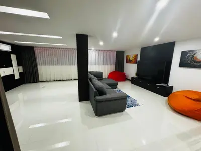 a living room with a couch and a flat screen tv at Sunrise Villa 21 in Phuket Town