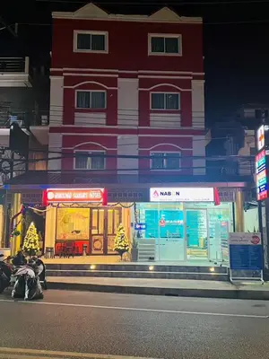 a red and white building on the side of a street at Sunray Beach Hotel Patong in Patong Beach
