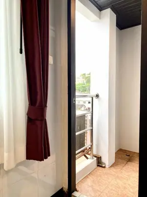 a room with a window and a curtain at Sunray Beach Hotel Patong in Patong Beach