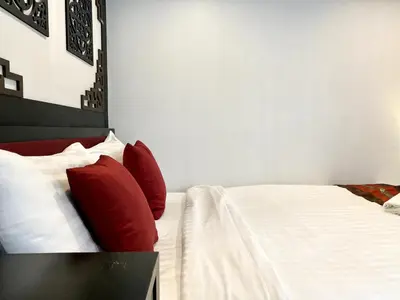a bedroom with a bed with red pillows at Sunray Beach Hotel Patong in Patong Beach