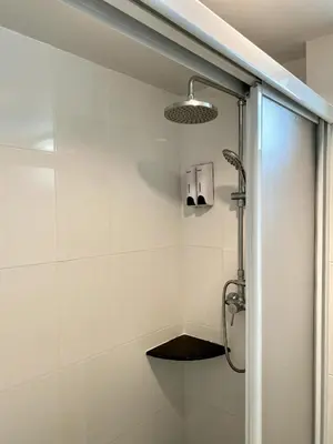 a bathroom with a shower with a glass door at Sunray Beach Hotel Patong in Patong Beach