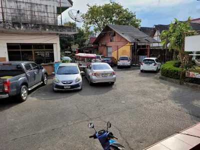 a parking lot with cars and a scooter parked at 2 Vikings Guesthouse in Karon Beach