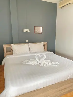 a white bed with a white flower on it at 2 Vikings Guesthouse in Karon Beach