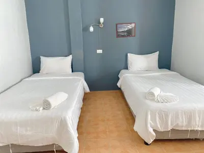 two beds in a room with white sheets at 2 Vikings Guesthouse in Karon Beach
