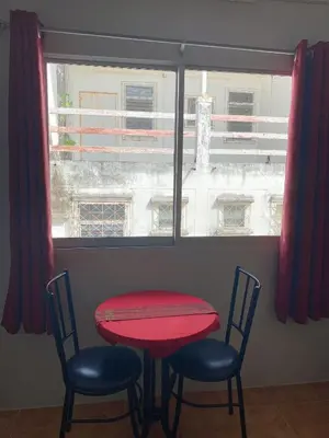 a red table and two chairs and a window at 2 Vikings Guesthouse in Karon Beach