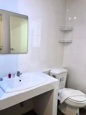 a white bathroom with a sink and a toilet at Kata Beach Guesthouse in Kata Beach