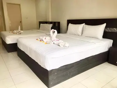 two stuffed animals are sitting on a bed at Kata Beach Guesthouse in Kata Beach