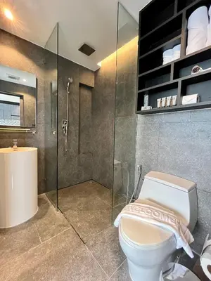 a bathroom with a toilet and a shower and a sink at Kamala Beach P72 Exclusive Junior Suite in Phuket Town